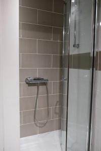 a shower with a glass door next to a tile wall at York House Durham in Durham +31 photos