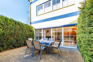 eine Terrasse mit einem Tisch und Stühlen vor einem Gebäude in der Unterkunft Haus Jasmund in Binz