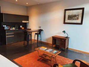 a living room with a table and a kitchen at Augusta Hotel in Valparaíso