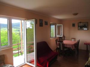 a living room with a table and a balcony at Guesthouse Borovi in Nova Varoš
