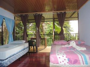 two beds in a room with a balcony at LookOut DrakeBay in Drake