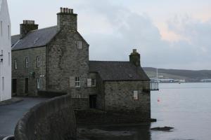 an old brick building next to the water at 16 Mounthooly Street in Lerwick