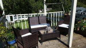 2 chaises en osier et une table sur une terrasse dans l'établissement Blue Peter hotel, à Stranraer