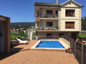 a house with a swimming pool in front of a house at Apartamento vacacional Poio-Rias Baixas in Poio