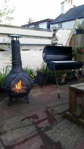 a grill and a fire pit in a backyard at Blue Peter hotel in Stranraer