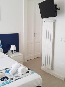 sypialnia z łóżkiem z telewizorem na ścianie w obiekcie B&B Flora w mieście Piazza Armerina