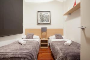 Een bed of bedden in een kamer bij Akira Flats Plaza Catalunya Centric apartments