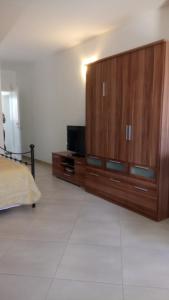 sypialnia z łóżkiem i dużą drewnianą szafką w obiekcie Studio Apartment Ivo w mieście Cres