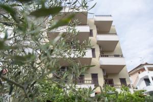 an apartment building with balconies and trees in the foreground at Thita Studios ex Anastasiadis House in Neos Marmaras