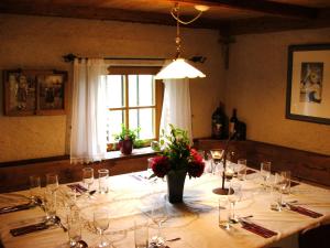a table with glasses and a vase of flowers on it at Apartment Furschermuehle in Siusi