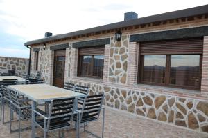 un patio con mesas y sillas frente a un edificio en Casa Rural "Vallecasar" en Los Navalucillos