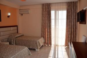 a hotel room with two beds and a window at Hotel Virginia in Durrës
