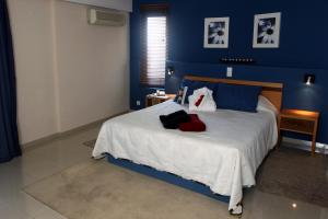 a bedroom with a large bed with blue walls at Rocamar Exclusive Hotel & Spa - Adults Only in Albufeira