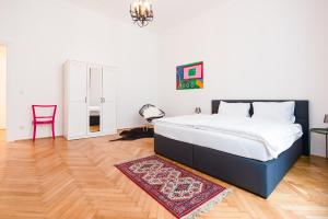 a bedroom with a large bed and a red chair at GRAND SOHO II Apartment Vienna in Vienna