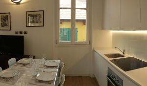 a kitchen with a table with chairs and a sink at Appartamento i Tulipani - 2 in Griante Cadenabbia