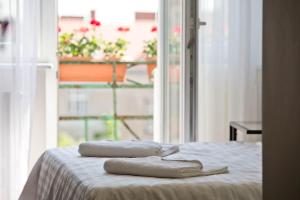 ポズナンにあるR&B APARTMENTS POZNAŃの窓付きのベッドの上に座るタオル2枚