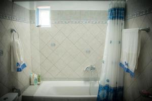 a bathroom with a tub and a shower curtain at Katsinaros House in Emporio Santorini