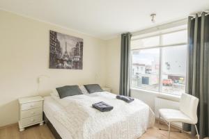 a bedroom with a bed and a large window at Acco Town Square Apartments in Akureyri +50 photos