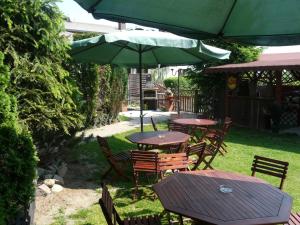 a group of tables and chairs with an umbrella at Villa Vivian in Szczecin