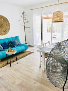 a living room with a blue couch and a table at Cabaña Cala Saona in Sant Francesc Xavier