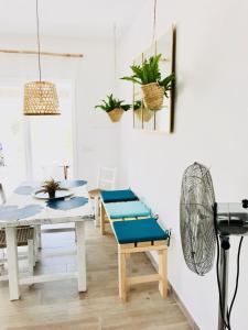 a dining room with a table and a blue bench at Cabaña Cala Saona in Sant Francesc Xavier