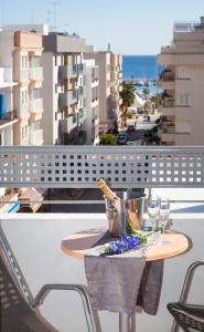 a table on a balcony with wine glasses at Apartamentos Parot Quality in Santa Eularia des Riu