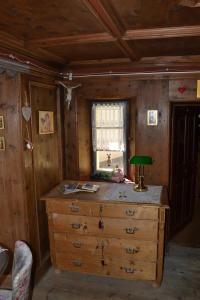 een houten kamer met een dressoir en een raam bij B&B La Tana dell'Orso - Die Bärenhöhle in Castello di Fiemme