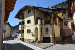 een geel gebouw aan de straatkant bij B&B La Tana dell'Orso - Die Bärenhöhle in Castello di Fiemme