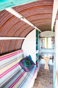 a bed in a tiny house with a wooden ceiling at Clissmann Horse Caravans Glamping in Rathdrum