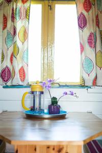 a table with a coffee pot and flowers on it at Clissmann Horse Caravans Glamping in Rathdrum