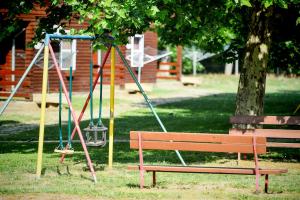 a park with a bench and a swing at Oliver Inn in Balatonlelle