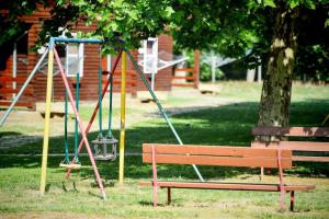 un parque con un banco y un columpio en Oliver Inn, en Balatonlelle