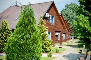 uma casa com uma árvore em frente em Oliver Inn em Balatonlelle