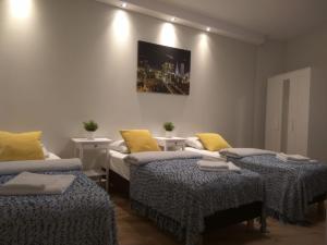 Habitación con 2 camas y almohadas amarillas. en Klopot 4 Apartment, en Varsovia