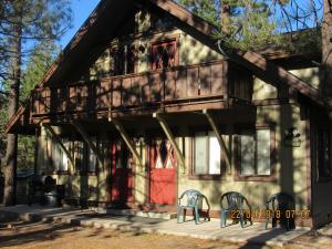 ein Haus mit einer roten Tür und Stühlen davor in der Unterkunft Miller's Outpost in Big Bear Lake