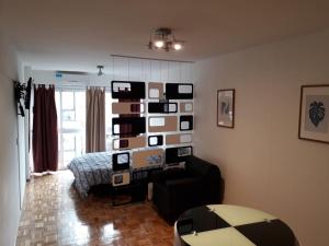 a living room with a wall of pictures on the wall at Downtown Viamonte Apartment in Buenos Aires