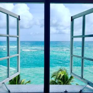 una finestra aperta che guarda fuori l'oceano di Ocean Edge Villa a Boscobel