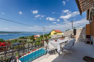 a balcony with a table and chairs and a view of the water at House Villa Ljuba in Crikvenica