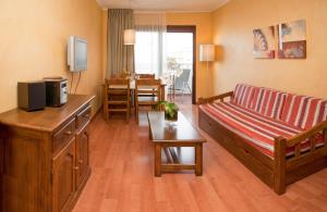 a living room with a couch and a table at Apartamentos Parot Quality in Santa Eularia des Riu
