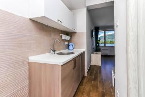 a kitchen with a sink and wooden floors at Apartments Maestral in Tivat +78 photos
