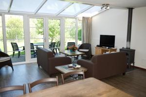 Una sala de estar con un sofá y sillas y un televisor. en Antibes 252 - Kustpark Village Scaldia, en Hoofdplaat