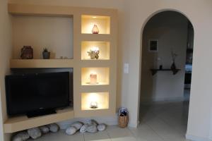 a living room with a flat screen tv on a wall at Kefalonian Oneira Villas in Mousata