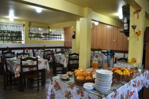 un restaurante con una mesa con platos y fruta. en Hotel Pousada Dos Pinheiros, en Canela