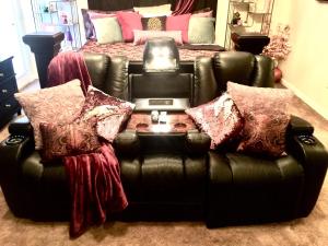 a black leather couch with pillows in a living room at Premier National Harbor House in Fort Washington