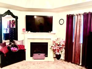 a living room with a fireplace with a tv above it at Premier National Harbor House in Fort Washington