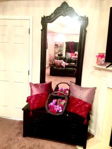 a room with a mirror and a bench with flowers at Premier National Harbor House in Fort Washington