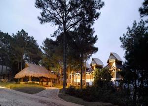 a large house with a thatched roof at Ri Kynjai Serenity by The Lake in Shillong