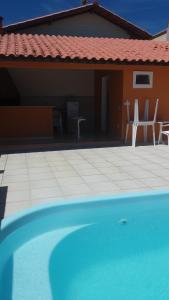 una piscina azul frente a una casa en Guest House Paraiso Pataxos, en Porto Seguro