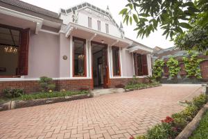 a brick driveway in front of a house at Huis Van Gustafine Floor 1 in Malang