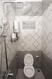 een kleine badkamer met een toilet en een foto aan de muur bij Huis Van Gustafine Floor 1 in Malang